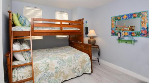 a bedroom with two bunk beds and a mirror at 409 Mariners Club in Key Largo