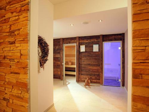 a room with a stone wall and a hallway with a cat at Ferienhaus Gartentraum 1 in Itter