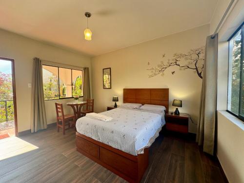 a bedroom with a bed and a table with chairs at Casa Hotel Mamaluna in Lunahuaná