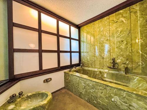 a bathroom with a tub and a large window at Holiday Home Haus Sophie by Interhome in Schladming