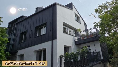 a white and black building with a black roof at Willa 4U in Rumia