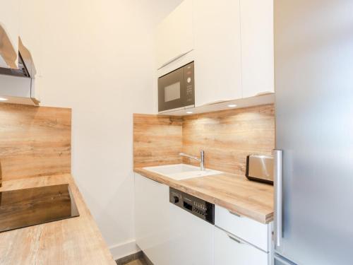 une cuisine avec un évier et un micro-ondes dans l'établissement Apartment L'hôtel de Paris by Interhome, à Trouville-sur-Mer