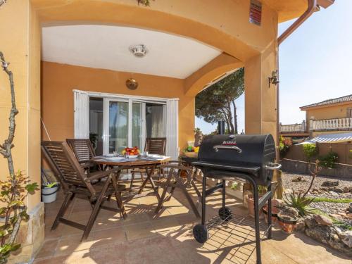 a patio with a grill and a table and chairs at Holiday Home Villa Meli by Interhome in Vidreres