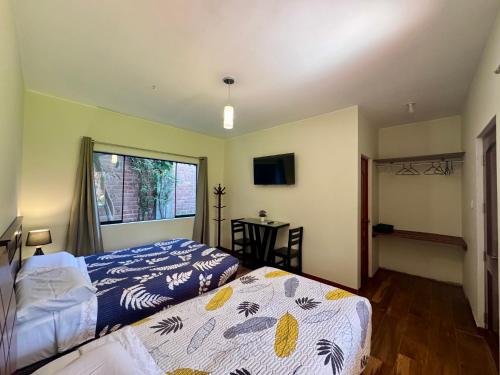 a bedroom with two beds and a window at Casa Hotel Mamaluna in Lunahuaná