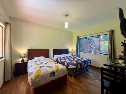 a bedroom with two beds and a window at Casa Hotel Mamaluna in Lunahuaná