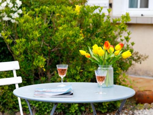 une table avec deux verres et un vase de fleurs dans l'établissement Holiday Home L'Horizon by Interhome, à La Bernerie-en-Retz