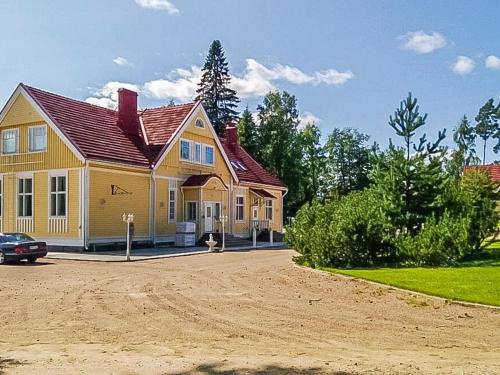 a yellow house with a red roof on a dirt road at Holiday Home Vilppulan huvila by Interhome in Suluslahti