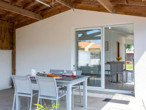 une salle à manger avec une table et des chaises sur un patio dans l'établissement Holiday Home L'Effet Mer by Interhome, à La Bernerie-en-Retz