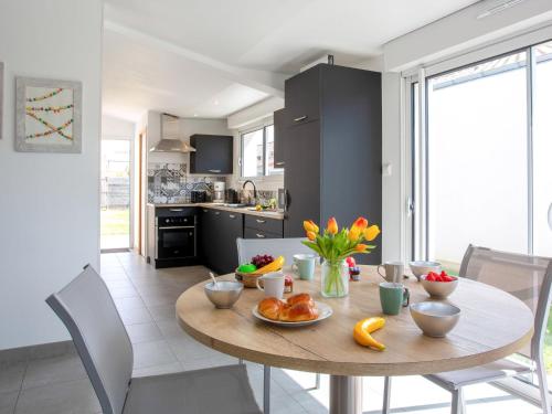 une cuisine et une salle à manger avec une table avec des fruits dessus dans l'établissement Holiday Home L'Effet Mer by Interhome, à La Bernerie-en-Retz