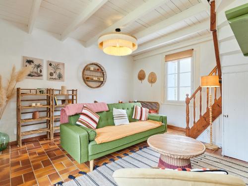 un salon avec un canapé vert et une table dans l'établissement Holiday Home Cottage Carolles by Interhome, à Carolles
