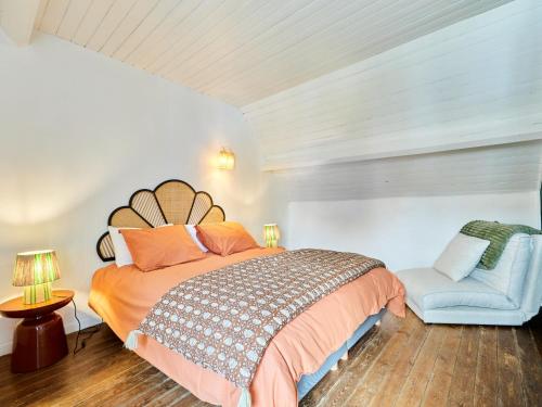 une chambre avec un grand lit et une chaise dans l'établissement Holiday Home Cottage Carolles by Interhome, à Carolles