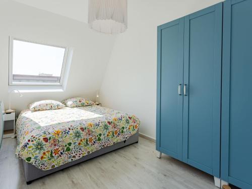 - une chambre avec un lit et une armoire bleue dans l'établissement Apartment Deauville Plage 1 et 2-27 by Interhome, à Villers-sur-Mer
