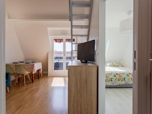 Cette chambre comprend un lit et une télévision sur une commode. dans l'établissement Apartment Deauville Plage 1 et 2-27 by Interhome, à Villers-sur-Mer