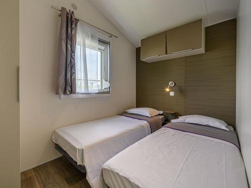 カルナックにあるApartment L'avocette by Interhomeの窓のある小さな部屋にベッドが2つある