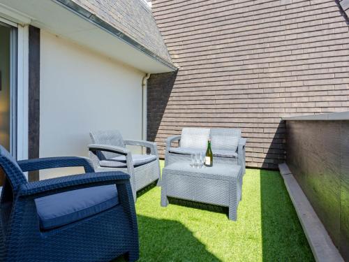 - une terrasse avec des chaises et une table avec une bouteille de vin dans l'établissement Apartment Cap Cabourg-33 by Interhome, à Cabourg