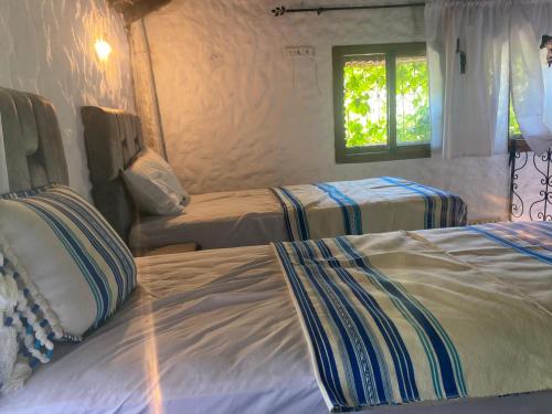a bedroom with two beds and a window at Casa Tissemlal in Chefchaouene