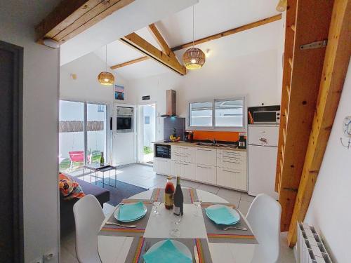 une cuisine et une salle à manger avec une table et des chaises dans l'établissement Apartment Les Galivades by Interhome, à LʼHerbaudière