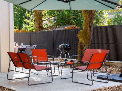 un grupo de sillas y una mesa con sombrilla en Holiday Home Ohana by Interhome, en Saint-Brévin-lʼOcéan