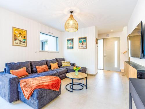 un salon avec un canapé bleu et une table dans l'établissement Holiday Home Ohana by Interhome, à Saint-Brévin-lʼOcéan