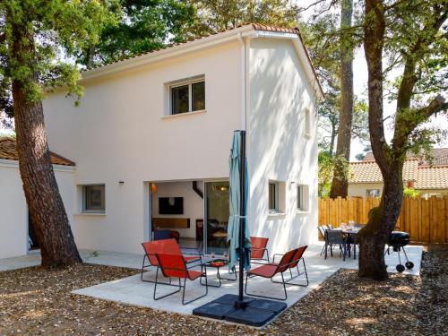 une maison avec des chaises et une table dans une cour dans l'établissement Holiday Home Ohana by Interhome, à Saint-Brévin-lʼOcéan