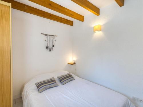une chambre avec un lit blanc avec deux oreillers dessus dans l'établissement Apartment Maylis-2 by Interhome, à Saint-Palais-sur-Mer