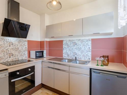 une cuisine avec des armoires blanches et un évier dans l'établissement Apartment La Voilerie-3 by Interhome, à Cabourg