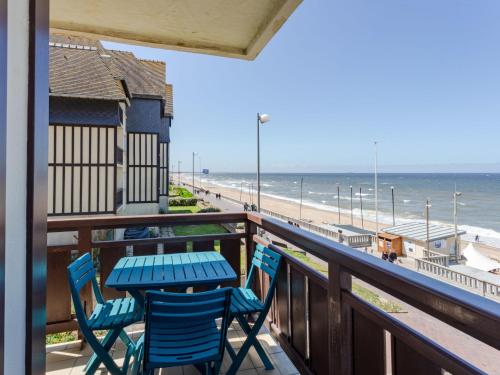 - un balcon avec une table et des chaises et la plage dans l'établissement Apartment La Voilerie-3 by Interhome, à Cabourg