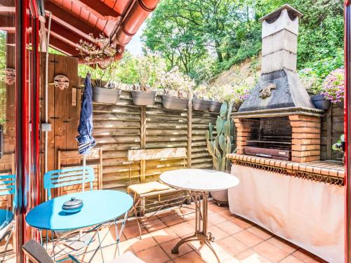 d'une terrasse avec une table, des chaises et un four extérieur. dans l'établissement Apartment ARROUNZ by Interhome, à Biriatou