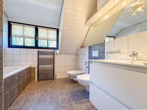 a bathroom with a toilet and a tub and a sink at Rosegarden in Bruinisse