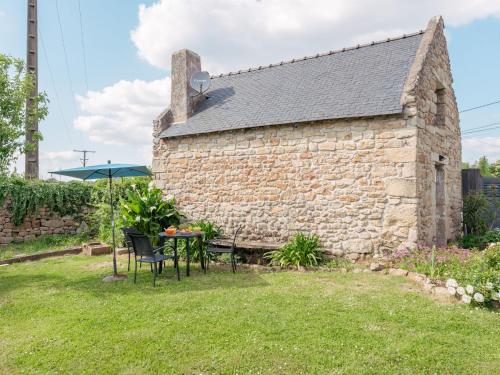 - un bâtiment en pierre avec une table et un parasol dans l'établissement Holiday Home Le Nid du Soleil by Interhome, à Carnac
