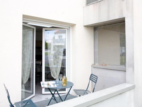 une table et des chaises sur un balcon avec une fenêtre dans l'établissement Studio Résidence de la Source by Interhome, à Prigny