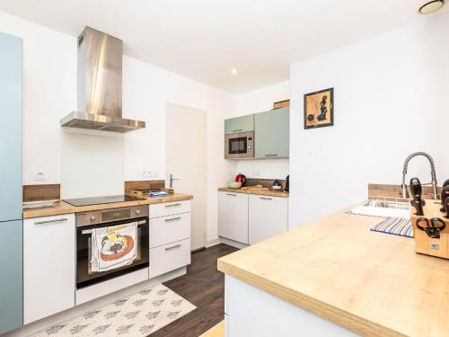 une cuisine avec des armoires blanches et un comptoir dans l'établissement Holiday Home Le Petit Moulin by Interhome, à Cancale