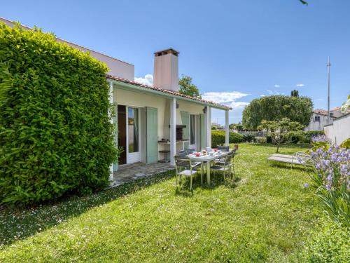 - un petit jardin avec une table et des chaises en face d'une maison dans l'établissement Holiday Home Maison Pasteur by Interhome, à Vaux-sur-Mer