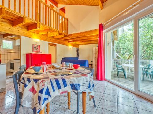une salle à manger avec une table et une grande fenêtre dans l'établissement Holiday Home Golf Loisirs 22 by Interhome, à Lacanau-Océan