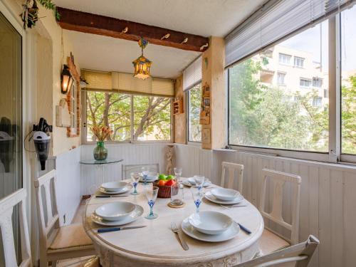 une salle à manger avec une table, des assiettes et des verres dans l'établissement Apartment L'Atalante-3 by Interhome, à Sainte-Maxime