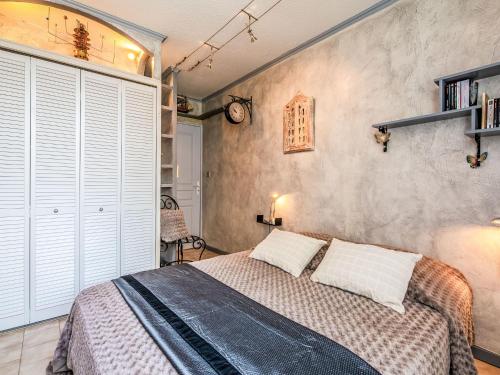 une chambre avec un lit et un mur avec des volets blancs dans l'établissement Apartment L'Atalante-3 by Interhome, à Sainte-Maxime
