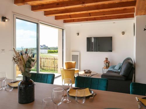 une salle à manger avec une table et des verres à vin dans l'établissement Holiday Home Les reflets bleus by Interhome, à Kerlouan