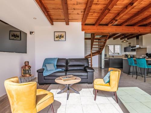 un salon avec un canapé et des chaises et une cuisine dans l'établissement Holiday Home Les reflets bleus by Interhome, à Kerlouan