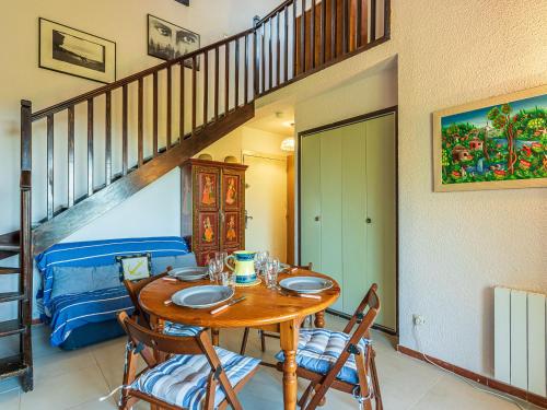 une salle à manger avec une table, des chaises et un escalier dans l'établissement Apartment Les Mas de Pramousquier-14 by Interhome, au Lavandou