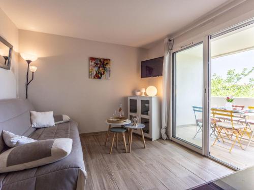 - un salon avec un lit et une porte coulissante en verre dans l'établissement Apartment Les terrasses de la Plage-6 by Interhome, au Cap d'Agde