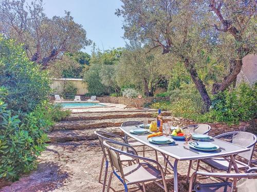 - une table et des chaises blanches dans une cour avec une piscine dans l'établissement Holiday Home Les Oliviers by Interhome, à Laouque
