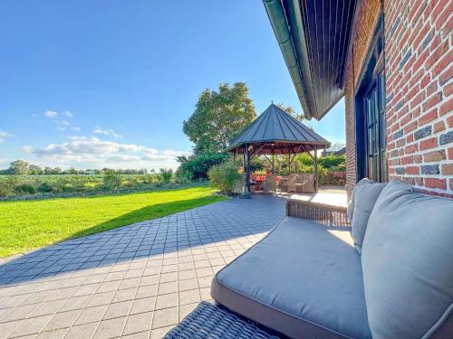 a couch sitting on a patio with a gazebo at Rosegarden in Bruinisse
