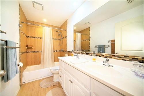 un bagno con lavandino, vasca e WC di "Blue Diamond" heated pool house by the water a Cape Coral