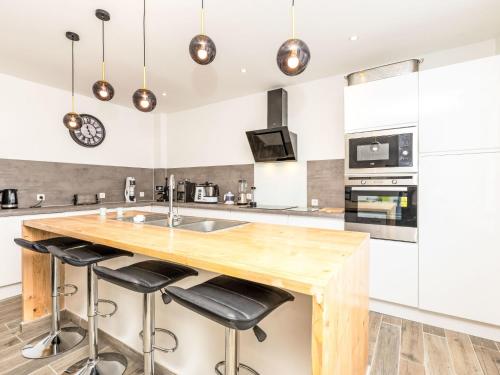 - une cuisine avec un comptoir en bois et des tabourets de bar dans l'établissement Holiday Home L'escale bretonne by Interhome, à Saint-Méloir-des-Ondes