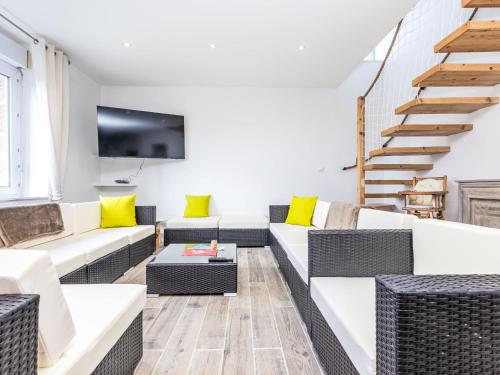 Elle comprend un salon doté d'un mobilier blanc et d'oreillers jaunes. dans l'établissement Holiday Home L'escale bretonne by Interhome, à Saint-Méloir-des-Ondes