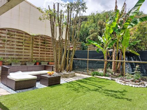 un jardin avec un banc, des arbres et de la pelouse dans l'établissement Holiday Home Villeneuve Plage by Interhome, à Villeneuve-Loubet