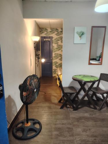 a room with a table and chairs and a fan at The Yellow House apartamentos independientes con cocina in Bajo Boquete