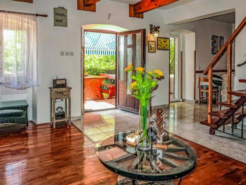 una sala de estar con una mesa de cristal con un jarrón de flores en Holiday Home Marija by Interhome, en Nedeščina