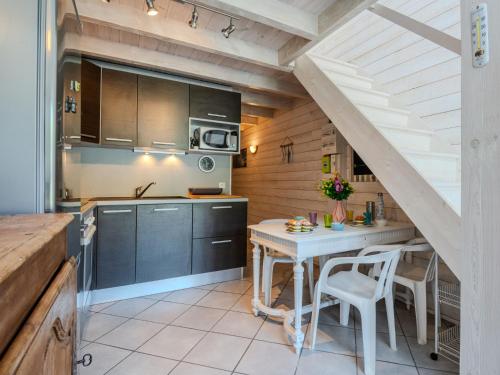 une cuisine avec une table et une cuisine avec un escalier dans l'établissement Apartment Les Malgaches-2 by Interhome, à Mimizan