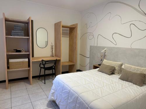 a bedroom with a bed and a desk and a chair at Departamento Sol Urbano in Rafaela